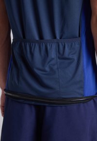 Ναυτική αθλητική μπλούζα με μπλε πάνελ, διαθέτοντας μα gathered τσέπη στην πλάτη και μαύρο φερμουάρ στο στρίφωμα. Απαλή, ελαφριά υφή.