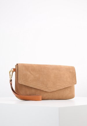 Bolso de mano de ante color marrón claro con solapa plegable y correa para la muñeca de cuero marrón desmontable sobre una superficie blanca.