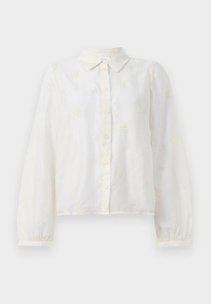 Hvit brodert skjorte med lange ermer, knappestolpe foran og kragehals. Små blomsterdesign pryder stoffet.