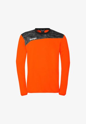 Maglia sportiva a maniche lunghe di colore arancione vivo con motivo geometrico nero sulle spalle e logo "Kempa" sul petto destro.