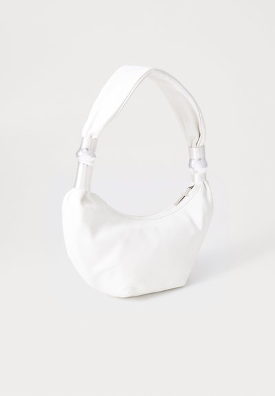 Balta ādas rokassoma ar mīkstu augšējo rokturi, kas satur caurspīdīgas plastmasas akcentus un rāvējslēdzēja slēgšanu augšpusē.