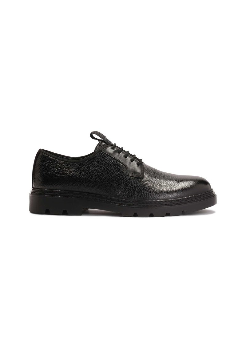 Zapatos de vestir de cuero negro con un acabado texturizado, punta redonda, diseño de cordones y suela de goma negra gruesa con patrones de relieve cortados.
