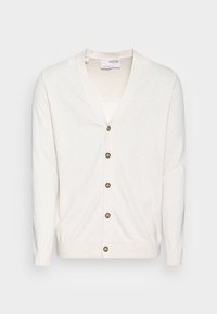 Krämfärgad kofta med V-ringning, sju bruna knappar fram och ribbade muddar. Tillverkad av lätt, texturerad tyg.