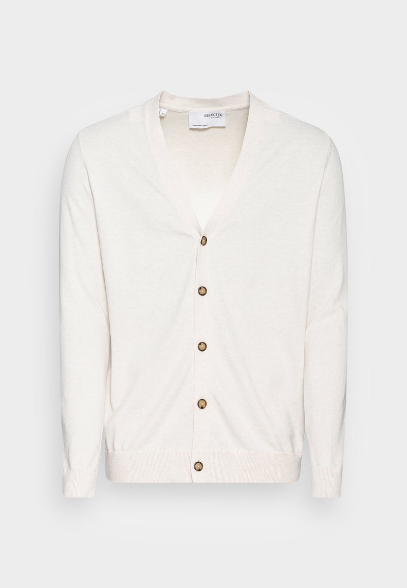 Krämfärgad kofta med V-ringning, sju bruna knappar fram och ribbade muddar. Tillverkad av lätt, texturerad tyg.