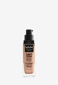 NYX Can't Stop Won't Stop foundation i en klar glasflaska med ett svart pumplock, som har en beige nyans och svart text på etiketten.