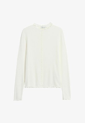 Weiße, gerippte Bluse mit langen Ärmeln und Rüschensaum entlang des Kragens, der vorderen Naht, der Manschetten und des Saums, vor einem einfarbigen Hintergrund präsentiert.