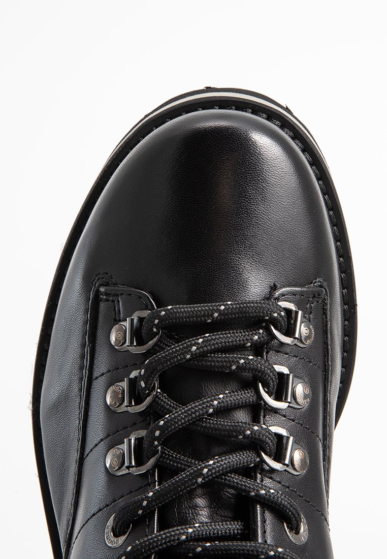 Schwarze Wanderstiefel aus Leder mit runder Zehenform, metallenen Ösen und strukturierten schwarzen Schnürsenkeln. Mit kontrastierendem weißen Stich entlang der Sohle.