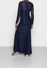Navy blue lace dress with long sleeves, embellished with sequins, fitted bodice, and flared skirt. Features a round neckline and back zipper.