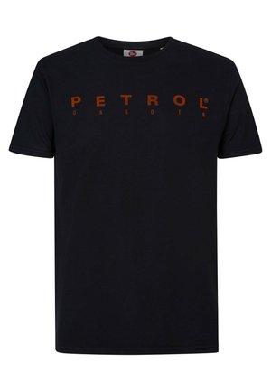 Camiseta de algodón negra de manga corta, con un llamativo texto en naranja que dice "PETROL DAKOTA" en el pecho. Diseño clásico de cuello redondo.