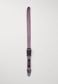 Lilla stofrem med en sort plastic spænde og en metalclips i den ene ende. Har en lille logo lap nær spændet.