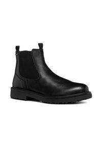 Botín Chelsea de cuero negro con paneles laterales elásticos, puntera redonda y suela de goma texturizada. Incluye tiradores para facilitar el uso.