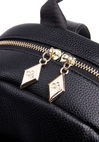 Zwarte leren rugzak met een gestructureerd oppervlak, voorzien van een gouden rits met diamantenvormige trekstangen. Het ontwerp omvat een bovenhandgreep en gebogen randen.