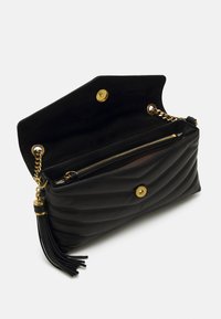 Borsa a pochette in pelle trapuntata nera con hardware dorato; presenta una parte superiore aperta, una tasca interna con zip e un ornamento a frangia sul lato.
