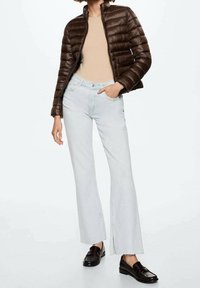 Brown puffer jacket, beige top, light blue flared jeans with raw hem, and black loafers. Smooth fabric and casual fit throughout.