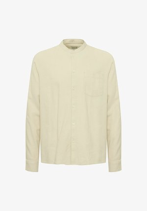 Chemise beige clair à manches longues avec un col montant, fermeture par boutons sur le devant et une poche poitrine. Texture lisse et coupe décontractée.