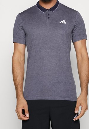 Graues Poloshirt mit einem marineblauen Kragen, kurzen Ärmeln, einer Knopfleiste mit drei Knöpfen und einem weißen Adidas-Logo auf der linken Brust. Glatte Textur.