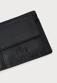 Porte-cartes en cuir noir avec une texture lisse, doté d'une poche avant et d'un logo RFID embouti. Les bords cousus ajoutent à la durabilité.