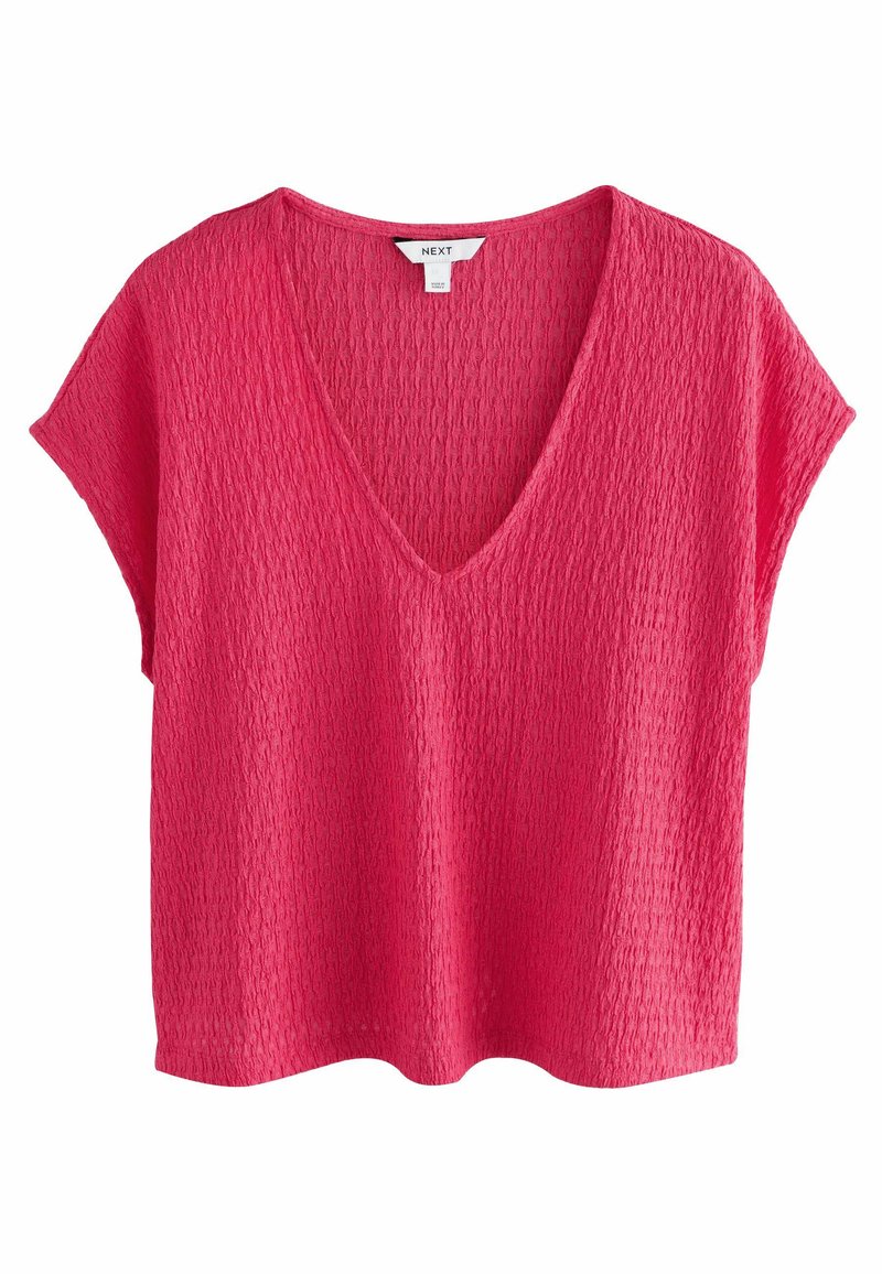 Haut à manches courtes texturé en rose vif avec un décolleté en V profond. Fabriqué en matériau léger, il présente une coupe décontractée et un ourlet courbé.