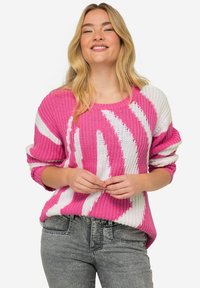 Stickad tröja med djärva rosa och vita abstrakta mönster, rund halsringning, långa ärmar och en avslappnad passform.