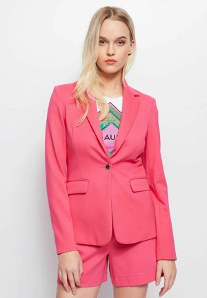 Blazer rosa con design strutturato, caratterizzato da una chiusura frontale a bottoni, due tasche e una texture di tessuto liscia, abbinato a pantaloni corti coordinati.