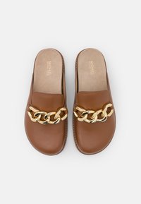 Mocassins en cuir marron à enfiler avec un détail en chaîne dorée sur le dessus et des semelles intérieures beiges rembourrées de la marque Michael Kors.