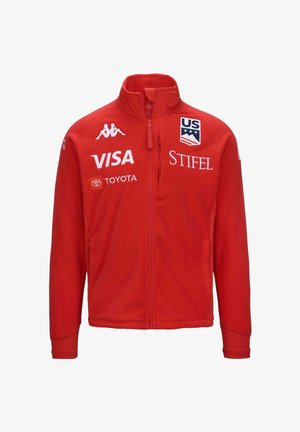 Giacca in pile rossa con colletto alto, zip completa e polsini a coste. Presenta loghi tra cui US Ski Team, VISA e STIFEL. Texture morbida.