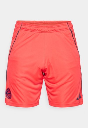 Erksavärvilised roosad spordipüksid elastse vöökohaga, tumesiniste küljeribadega ning FC Bayern Müncheni tikitud logoga alumises vasakus nurgas.