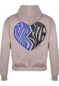 Helle beigefarbene Kapuzenjacke mit einem großen Herz-Graphic auf dem Rücken, das blaue und schwarze Wellenlinien zeigt. Abgeschlossen mit gerippten Bündchen und Saum.