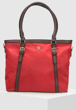 Rød syntetisk shopper-taske med brune læderdetaljer, dobbelthåndtag og en dekorativ logo i guld. Har et struktureret, rummeligt design.