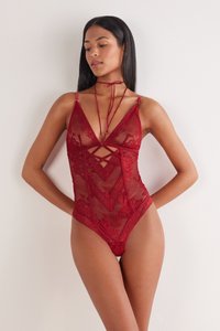 Roze kanten bodysuit met een driehoekige halslijn, kruiselings detail en verstelbare bandjes. Doorschijnende stof met bloemmotieven en een aansluitend silhouet.