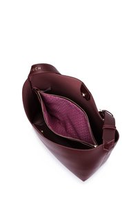 Burgundy leather handbag with a smooth texture, featuring a pink patterned interior, a zippered pocket, and a shoulder strap. Logo on top.