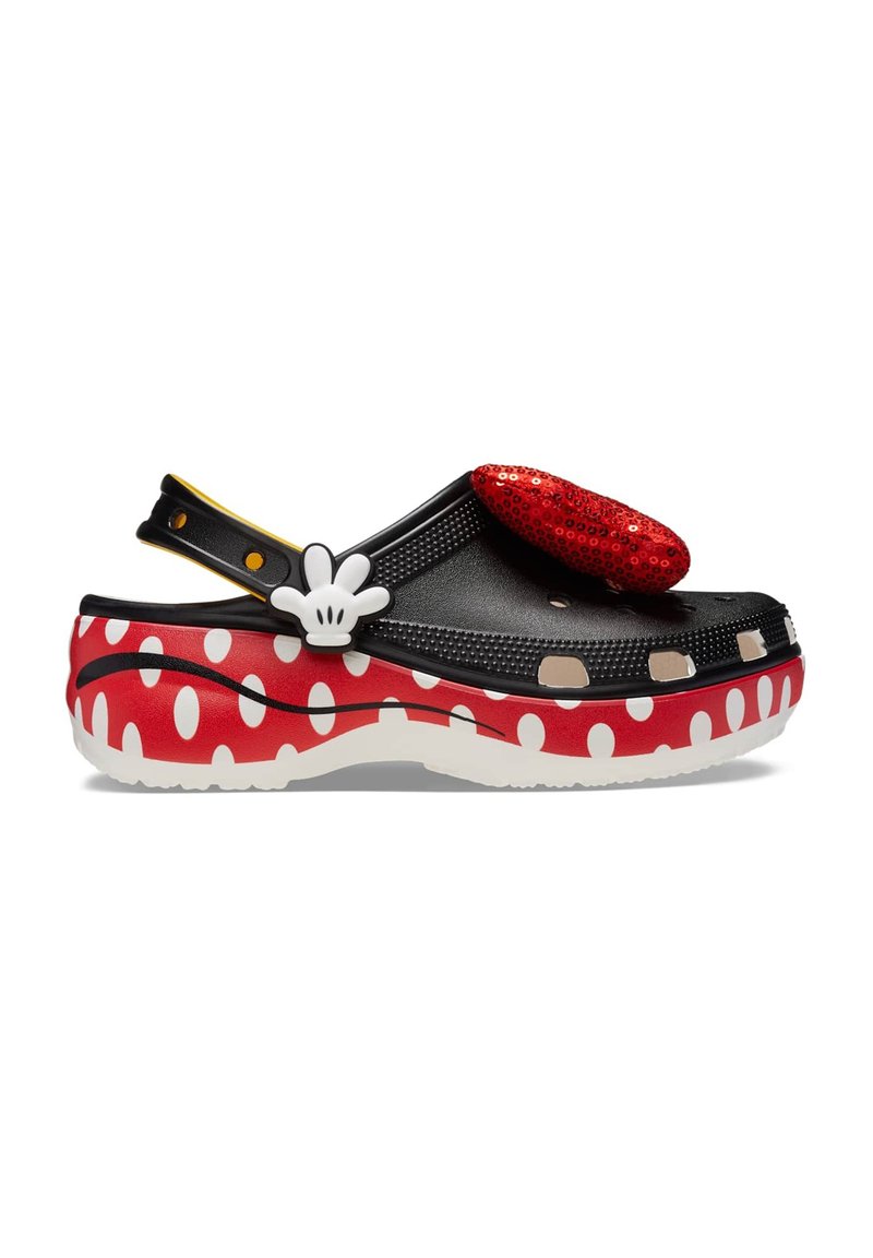 Schwarzer Clogs-Schuh mit rot-weißer gepunkteter Musterung, ausgestattet mit einer glitzernden roten Schleife, weißen Akzenten und verstellbarem Fersenriemen.