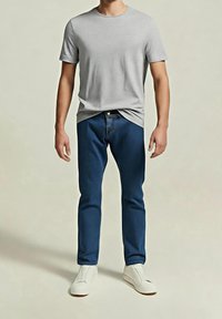 Šedé tričko s kulatým výstřihem, modré džínové rifle a bílé nazouvací boty. Oblečení má jednoduchý design a pohodlný střih.