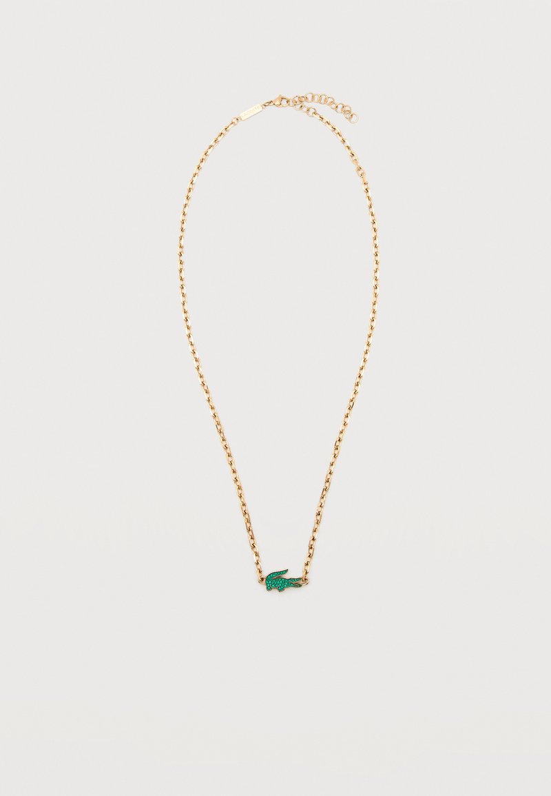 Χρυσή αλυσίδα με κρεμαστό σε σχήμα μικρού πράσινου κροκοδείλου από πέτρες σε λευκό φόντο.