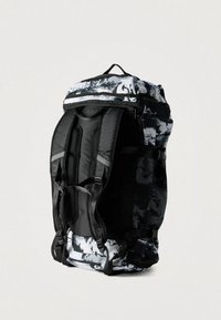 Ασπρόμαυρο σακίδιο με σχέδια, με επενδυμένους ιμάντες, τμήματα από δίχτυ, λαβή στο πάνω μέρος και πολλαπλά διαμερίσματα για αποθήκευση.