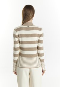 Rippstrickpullover mit vertikalen und horizontalen Streifen in Beige und Weiß, mit hohem Kragen und taillierter Passform.