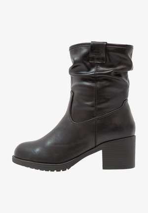 Black leather ankle boots with a slouchy design, round toe, and a chunky heel. Features textured detailing and a back tab.