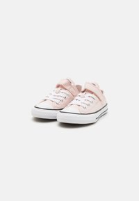 Zapatillas de lona rosa con cordones blancos, tira de Velcro, acento negro en la suela y puntera de goma redonda.