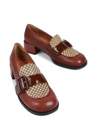 Brązowe skórzane buty na słupku z wzorem w houndstooth na przodzie i błyszczącym brązowym paskiem z klamrą. Okrągły czubek.