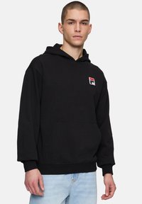 Musta fleece-huppari, jossa on etutasku, resorit hihansuissa ja helmassa. Taskun vasemmalla puolella on pieni, brodeerattu monivärinen logo. Rentomallinen.