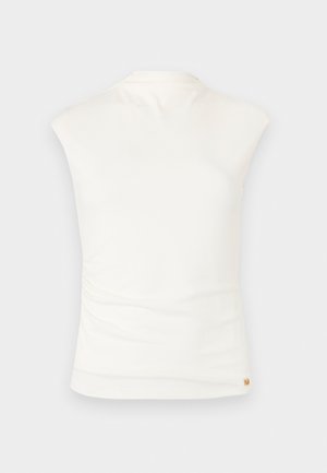 Ermeløs hvit topp med høy hals, glatt stoff og en liten gullfarget logotagg nær kanten, vist bakfra.