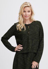 Czarny i zielony textured sweter z długim rękawem, okrągłym dekoltem i kluczykowym detalem z przodu. Posiada skróconą sylwetkę i miękką tkaninę.