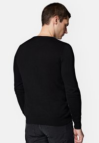 Czarny dzianinowy sweter z okrągłym dekoltem oraz ściągaczami przy mankietach i u dołu. Gładka textura i dopasowany krój. Pokazany z tyłu.