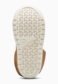 Semelle de chaussure en caoutchouc brun clair avec un motif texturé de petites étoiles et triangles. Présente un logo "Converse" en évidence.