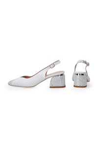 Białe buty typu slingback z perforowanym wierzchem, metalicznie srebrnym czubkiem i teksturowanym słupkowym obcasem z błyszczącymi srebrnymi akcentami.