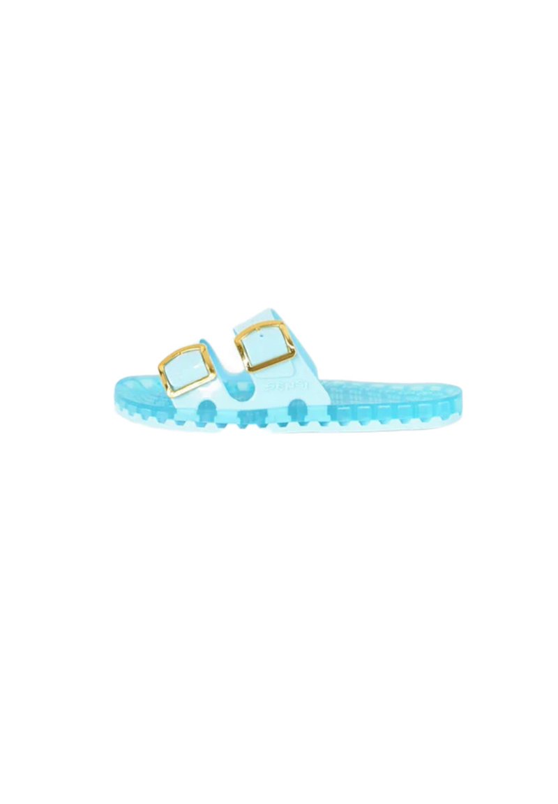 Chanclas transparentes de color azul claro con dos hebillas doradas ajustables, plantilla texturizada y suela con un patrón para mayor agarre.