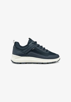 Zapatillas deportivas azul marino con una parte superior de malla texturizada y detalles en cuero liso, que cuentan con una entresuela blanca y una suela gris resistente.