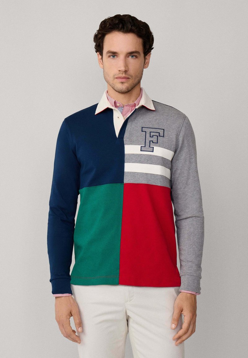 Langärmeliges Polohemd mit Abschnitten in Marineblau, Grün, Rot und Grau, mit einem cremefarbenen Kragen und einem blauen "F"-Logo auf der Brust.