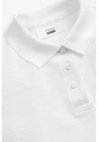 Polo shirt blanc avec un col festonné, une patte de boutonnage à trois boutons et un tissu texturé. L'étiquette indique "next SCHOOL."