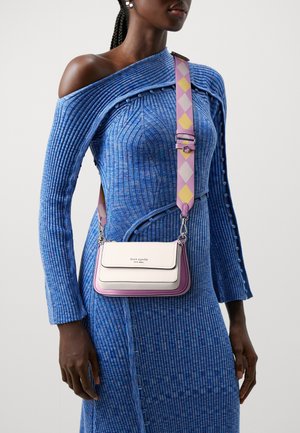 Mała torebka w różowo-białej kolorystyce z gładką skórzaną fakturą, srebrnym okuciem i wzorzystym, regulowanym paskiem.